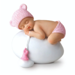 Figura niña bebé rosa durmiendo sobre huevo