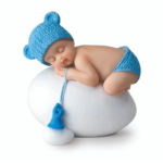 Figura niño bebé azul durmiendo sobre huevo